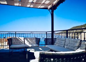 a patio with two couches and a table on a balcony at Komiza Provita Guesthouse in Komiža