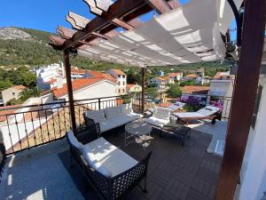 a patio with chairs and tables on a balcony at Komiza Provita Guesthouse in Komiža