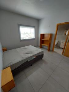 um quarto com uma cama e uma janela em Residencial Baldissera e Zeni em Machadinho