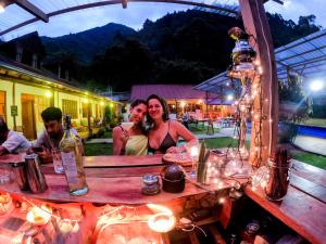 a man and woman sitting at a table in front of a mirror at Mama Tungu hostel in Baños