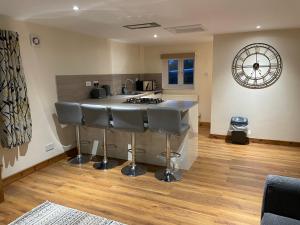 a kitchen with a counter and a island in a room at The Annex at Pantglas Farm in Pontyclun +6 photos