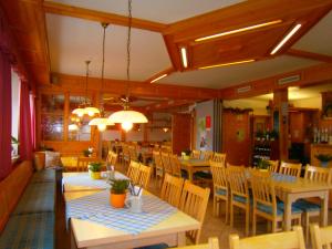 uma sala de jantar com mesas e cadeiras num restaurante em Gasthof Drei Linden em Obertrubach