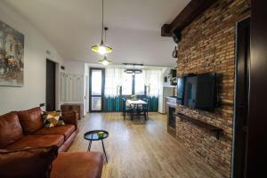 a living room with a couch and a brick wall at A lovely 2-bedroom apartment in central Tbilisi in Tbilisi City