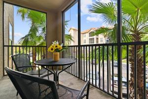 balkon ze stołem, krzesłami i palmami w obiekcie Minutes from Disney, Universal Studios and more! w mieście Kissimmee