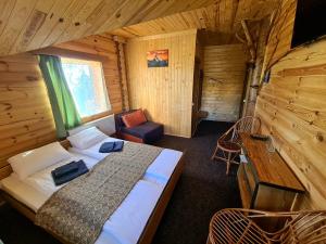 Dormitorio con cama y escritorio en una cabaña en Alpin Eco Chalet & Wellness en Dragobrat