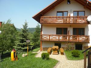 a house with a balcony and a picnic table at Willa Podgórska in Korbielów