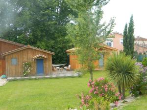 um jardim com uma casa e um quintal com flores em Chambre d'hôtes Larosa em Moulis-en-Médoc