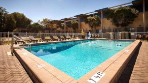 una piscina en un hotel con sillas alrededor en Best Western Crossroads Inn, en DeFuniak Springs