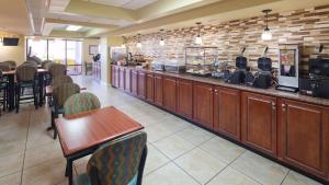 a restaurant with a bar with chairs and a counter at Best Western Ocean Sands Beach Resort in Myrtle Beach