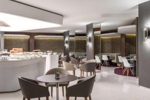 a restaurant with tables and chairs and a bar at NH Collection Brussels Grand Sablon in Brussels