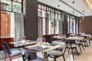 a restaurant with tables and chairs and windows at NH Collection Brussels Grand Sablon in Brussels