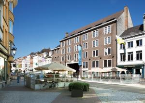 a street in a city with buildings and a bike at NH Mechelen in Mechelen