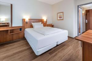 慕尼黑的住宿－慕尼黑Ost會議中心NH酒店，卧室配有一张白色大床和一张书桌