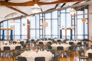 a banquet hall with tables and chairs and large windows at NH Bingen in Bingen am Rhein