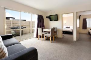 a living room with a couch and a table with chairs at 171 On High Motel in Blenheim