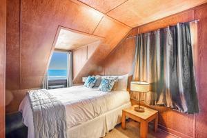 Un dormitorio con una cama con espejo y una ventana. en Coastal Serenity, en Lincoln City