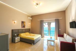 1 dormitorio con cama y vistas al océano en Apartments Serxhio, en Sarandë