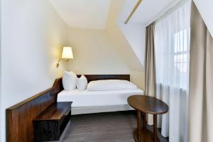 Postel nebo postele na pokoji v ubytování Hotel Klösterle Nördlingen - in Kürze elaya hotel kloesterle noerdlingen