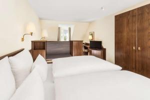 Postel nebo postele na pokoji v ubytování Hotel Klösterle Nördlingen - in Kürze elaya hotel kloesterle noerdlingen