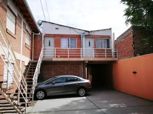 a car parked in a parking lot in front of a building at DEPARTAMENTOS Las Araucarias- 2 a 5 personas con estacionamiento in Neuquén