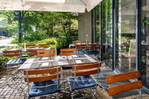 una fila de mesas y sillas en un restaurante en NH München Unterhaching, en Unterhaching