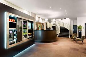 eine Lobby mit einer Bar und einer Treppe in einem Gebäude in der Unterkunft NH Amsterdam Caransa in Amsterdam