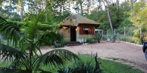 a small cabin with a thatched roof in a garden at Las chozas in Punta del Este