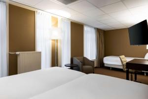 a hotel room with a bed and a desk at NH Centre Utrecht Hotel in Utrecht