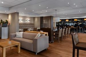 a restaurant with a couch and chairs and a bar at NH Zandvoort Hotel in Zandvoort