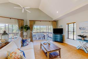 a living room with a white couch and a table at Bella By the Sea in Dauphin Island