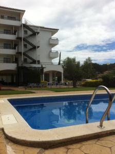 a swimming pool in front of a building at Bay Hotel in Roses