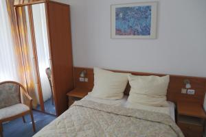 a bedroom with a bed and a chair at WIlla Maksymilian Bed and Breakfast in Bydgoszcz