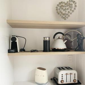 a shelf with a toaster and other appliances on it at Ohariu Farm Cottage in Johnsonville