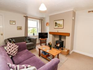 uma sala de estar com um sofá e uma lareira em Cleeve Cottage em Middleham