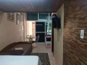 a room with a bed and a television on a wall at Apto Antunes terreo in Campos dos Goytacazes