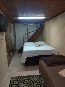 a small room with two beds and a television at Apto Antunes terreo in Campos dos Goytacazes