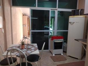 a small kitchen with a table and a refrigerator at Apto Antunes terreo in Campos dos Goytacazes