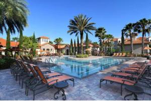 duży basen z krzesłami i palmami w obiekcie Minutes from Disney, Universal Studios and more! w mieście Kissimmee
