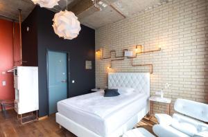 um quarto com uma cama branca e uma parede de tijolos em LOFTSTYLE Hotel Hannover, Best Western Signature Collection em Hanôver