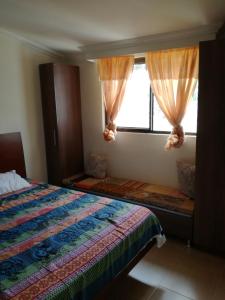 Schlafzimmer mit einem Bett und einem Fenster mit Vorhängen in der Unterkunft VISTALMONTE in Salento