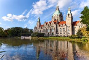 un grande edificio con un lago di fronte di NH Hannover ad Hannover