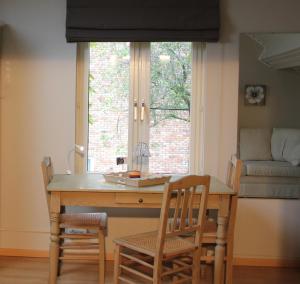a dining room table with chairs and a window at B&B Huize Bex in Overpelt