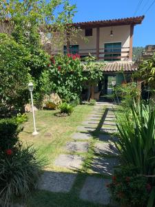 a garden with a walkway in front of a house at Sua casa in Angra dos Reis