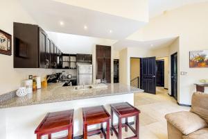a kitchen with a counter and two stools at The Cove 4 at Playa Ocotal in Coco +15 photos