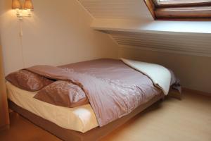 a small bed in a corner of a room at B&B Huize Bex in Overpelt