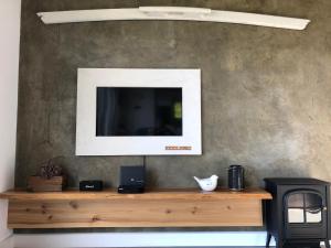 salon z telewizorem na drewnianej półce w obiekcie Casa da Arquinha w mieście Santo Amaro