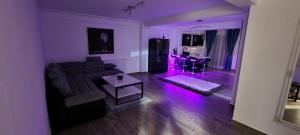 un salon avec un canapé et une table avec des lumières violettes dans l'établissement D3 ASP - VIVO Mall, à Floreşti