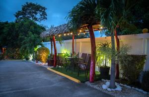 a patio with a table and chairs and palm trees at Hotel Boutique Meraki in Caldera