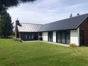 a house with a metal roof on a yard at 4 Bedroom on North West Arch - Free Wifi in Twizel