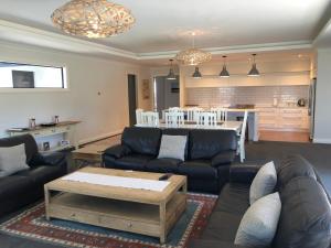 a living room with a couch and a table and a kitchen at 4 Bedroom on North West Arch - Free Wifi in Twizel